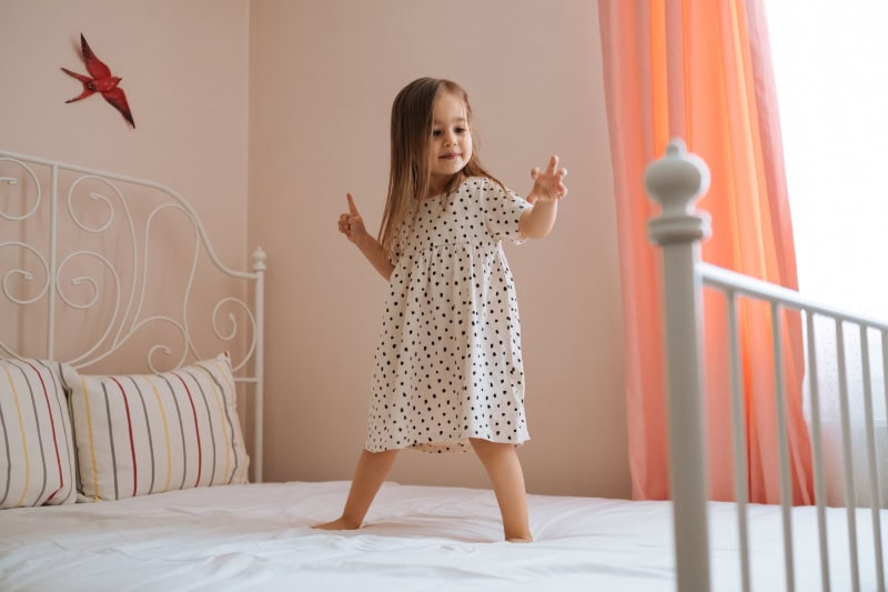 What You Should Know About Air Handlers. Photo of a little girl dancing or jumping on a bed.