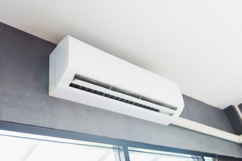 Ductless ACs Improve Indoor Air Quality and Control Humidity. Cool air conditioner swing system on wall in room.